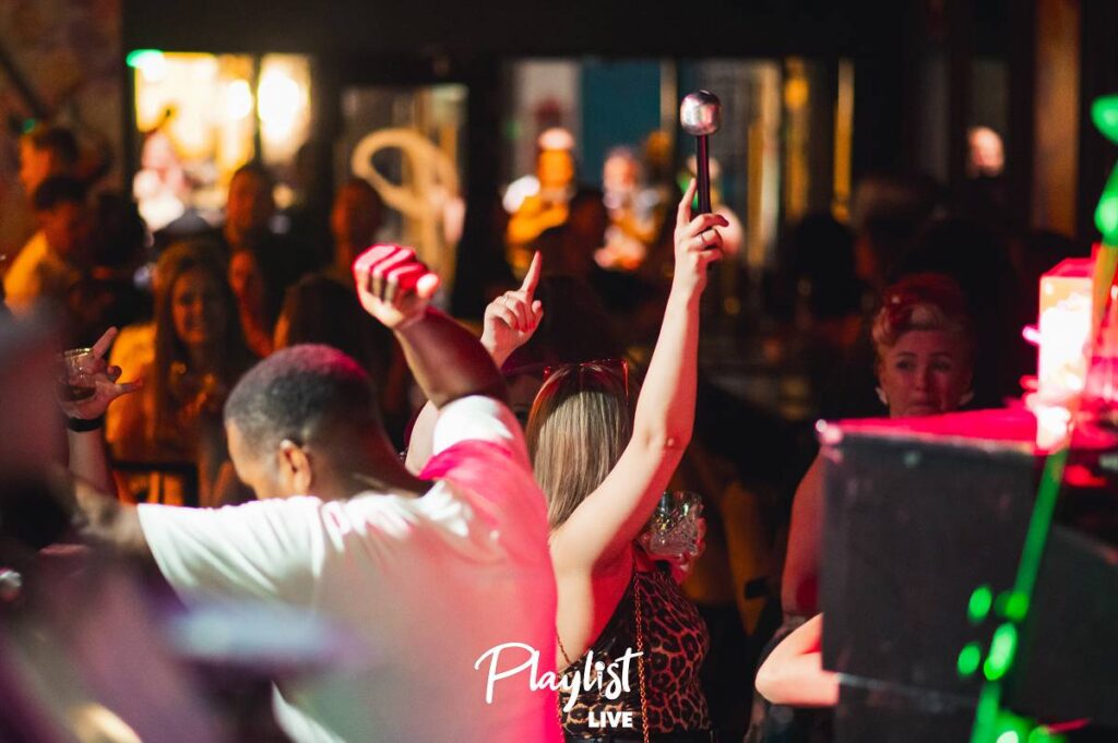 People dancing and enjoying live music during Friday night in Reading at Playlist Live, creating a lively and energetic atmosphere
